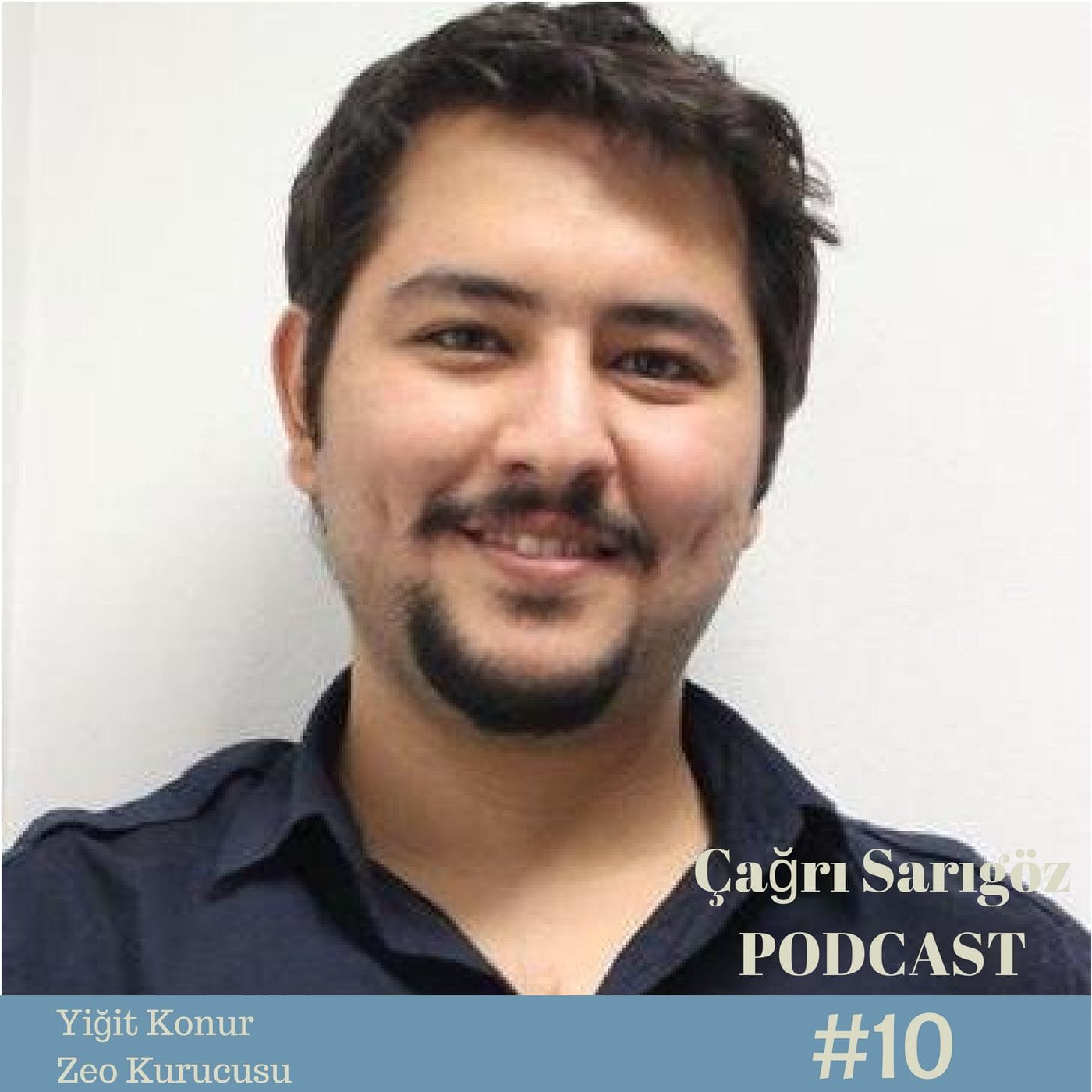 A man with a beard is smiling in front of a camera.