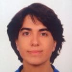 A young man in a blue shirt is posing for a photo.