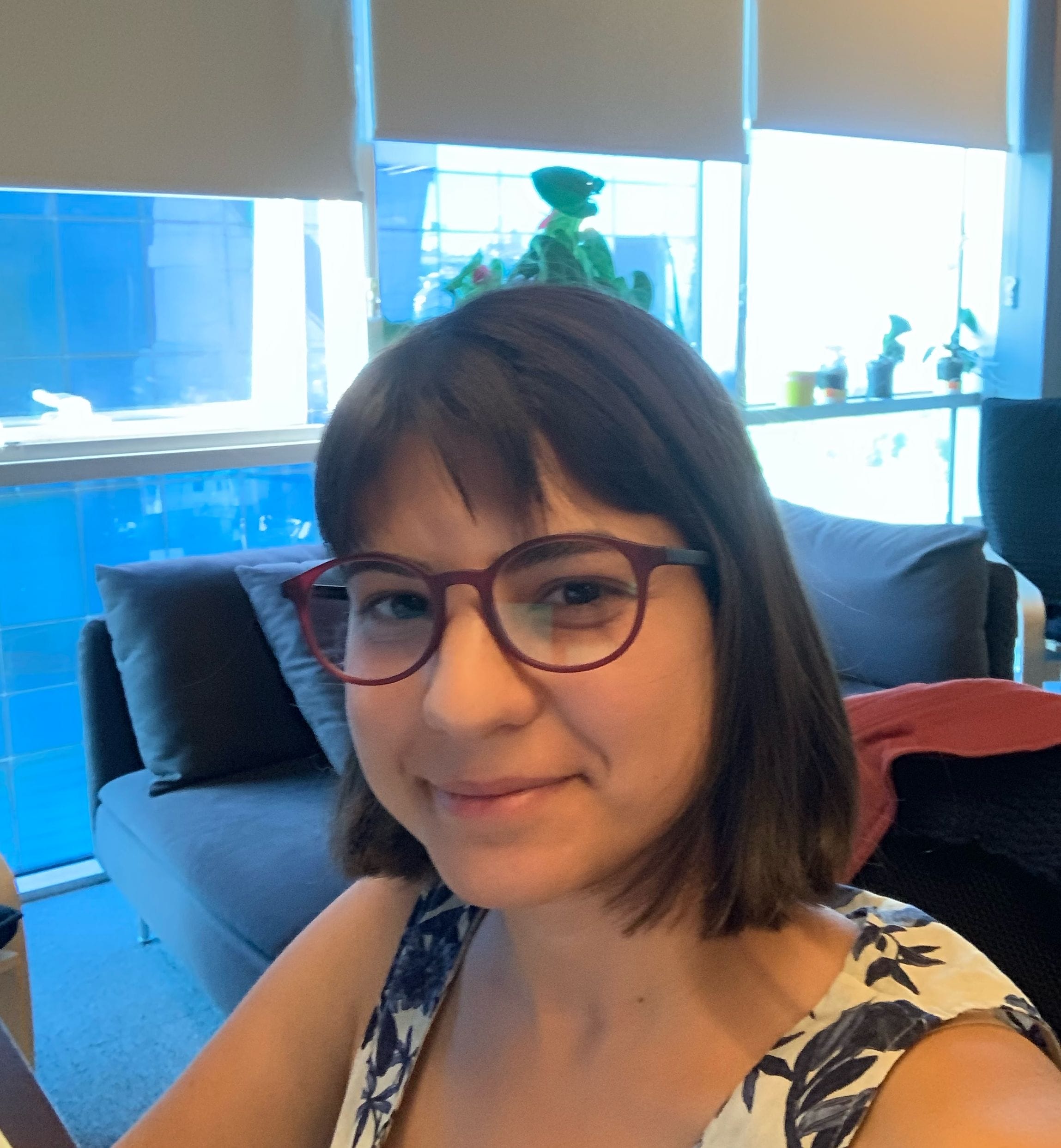 A woman in glasses sitting at a desk with a laptop.
