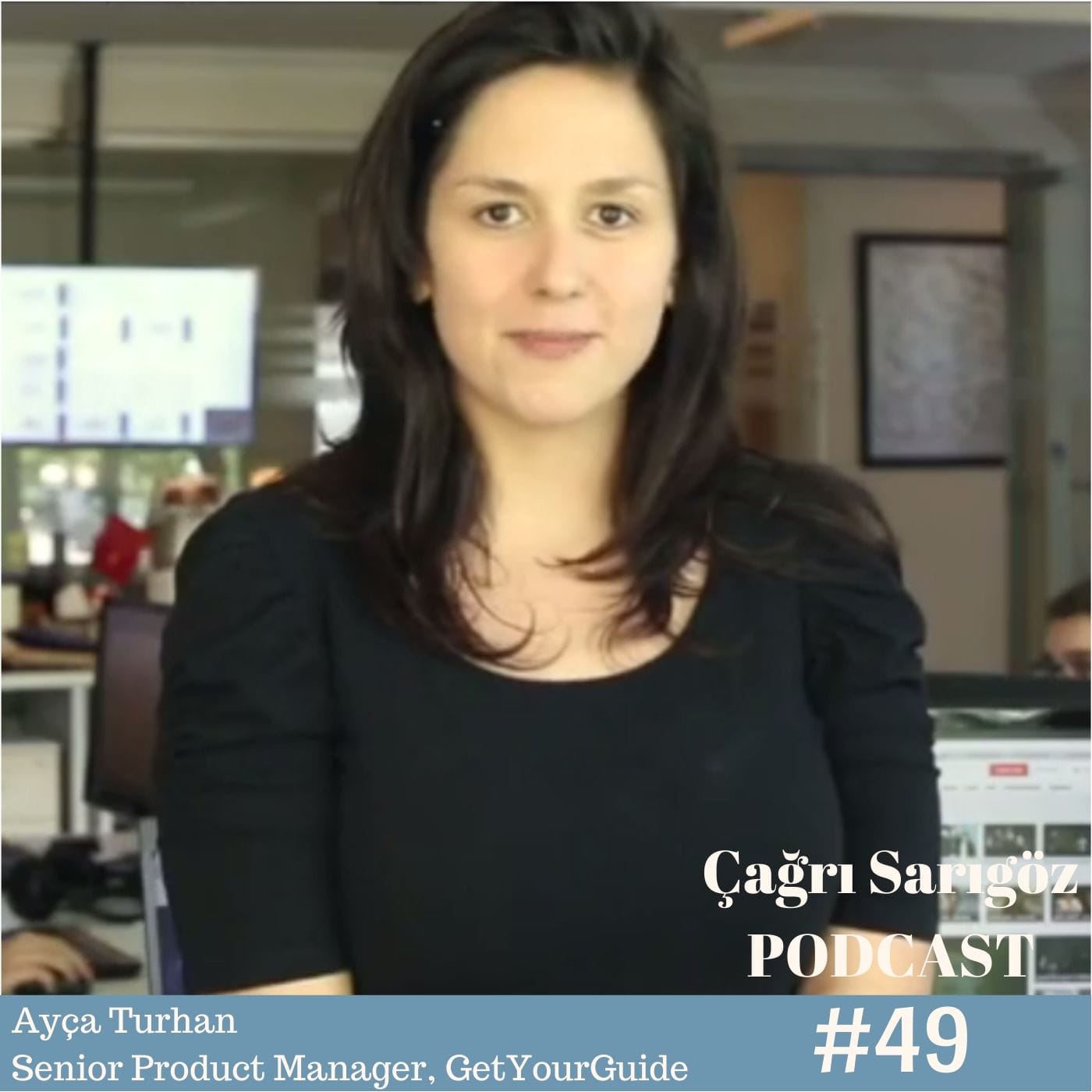 A woman in a black shirt is standing in front of an office.